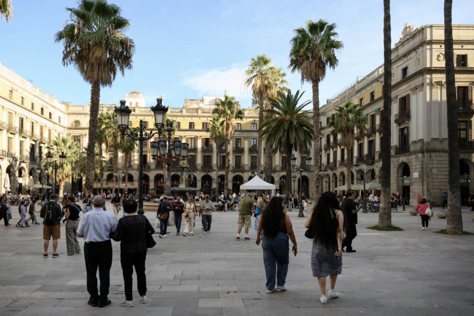 Tourists flock to a plaza in Barcelona Spain. <a href="https://www.gettyimages.com/detail/2182966379" rel="nofollow noopener" target="_blank" data-ylk="slk:NurPhoto/Getty Images;elm:context_link;itc:0;sec:content-canvas" class="link ">NurPhoto/Getty Images</a>