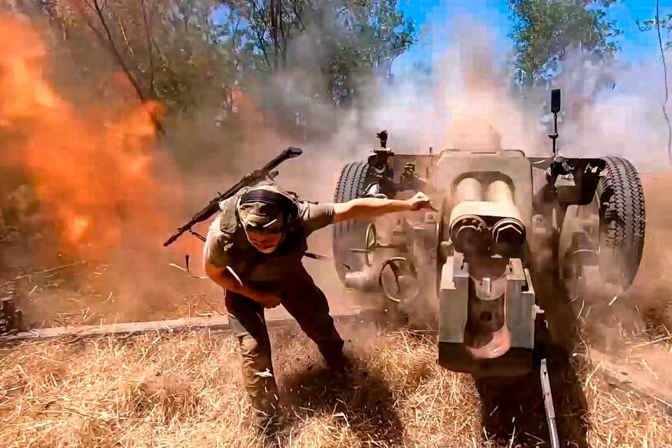 A Russian soldier firing a howitzer.