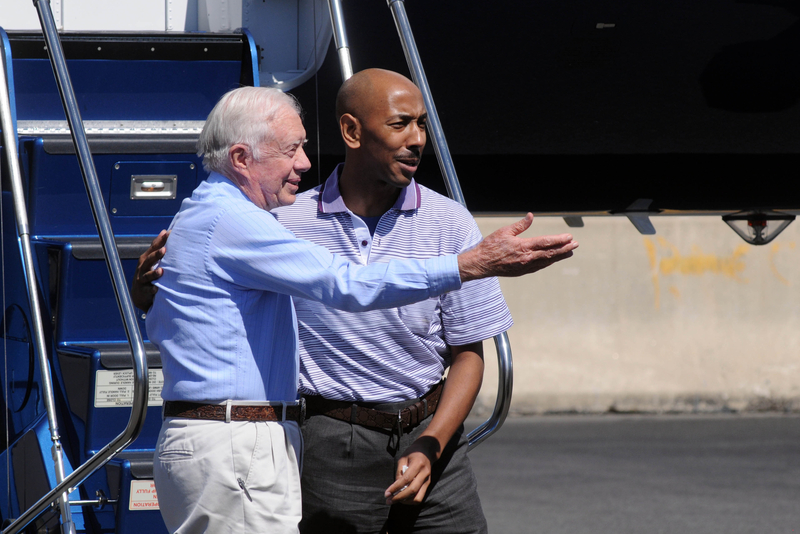 Carter steps off a plane with Aijalon Mahli Gomes on Aug. 27, 2010, in Boston. Gomes, held in custody in North Korea after crossing into the country illegally that January, was released at Carter's behest.