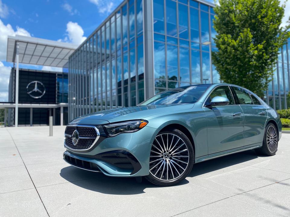 The left front of a light green 2024 Mercedes-Benz E450 sedan parked in front of Mercedes-Benz USA Headquarters in Atlanta.