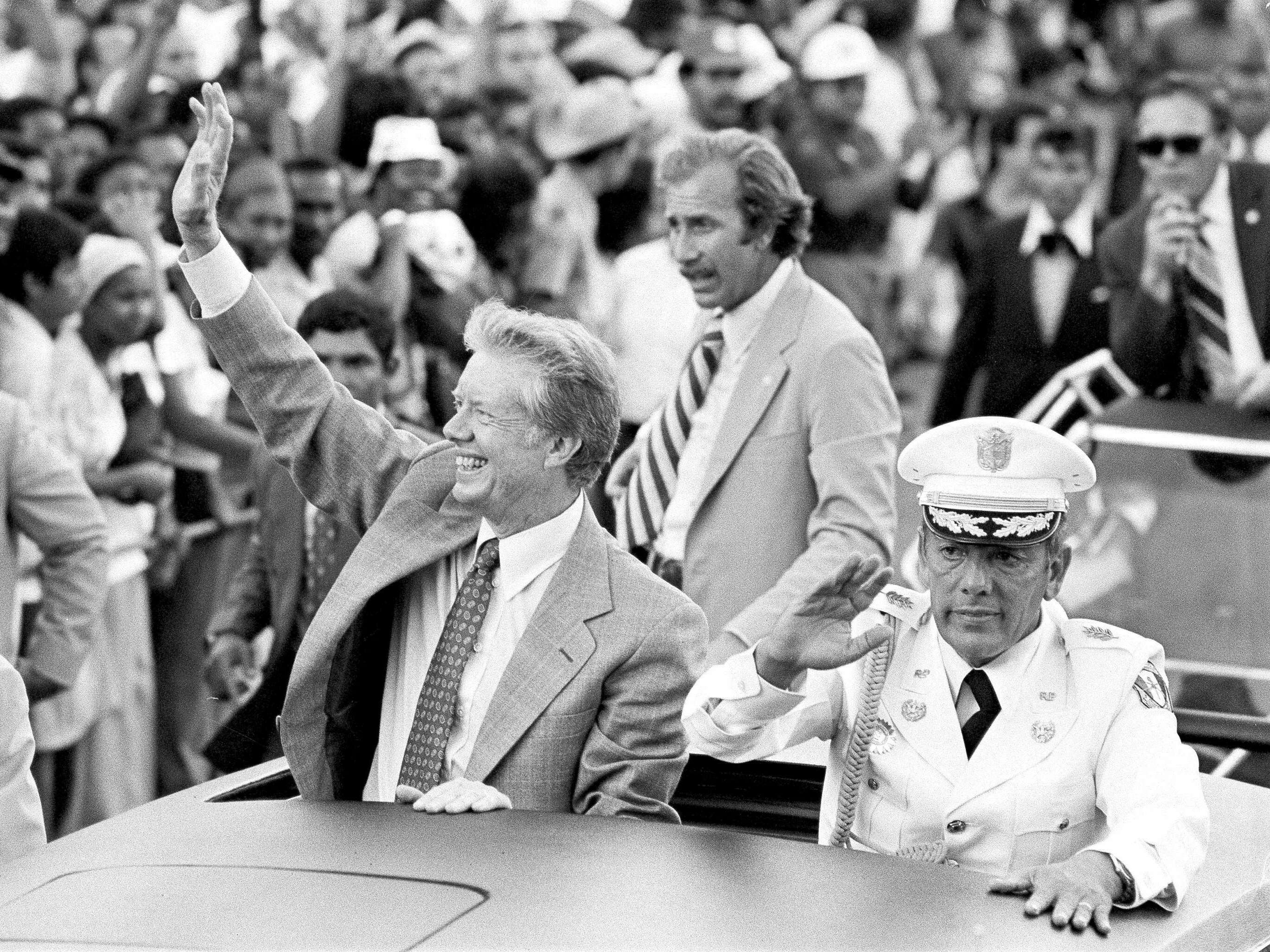 President Jimmy Carter and Gen. Omar Torrijos wave from an open car during a motorcade in Panama City, Panama, June 16, 1978.