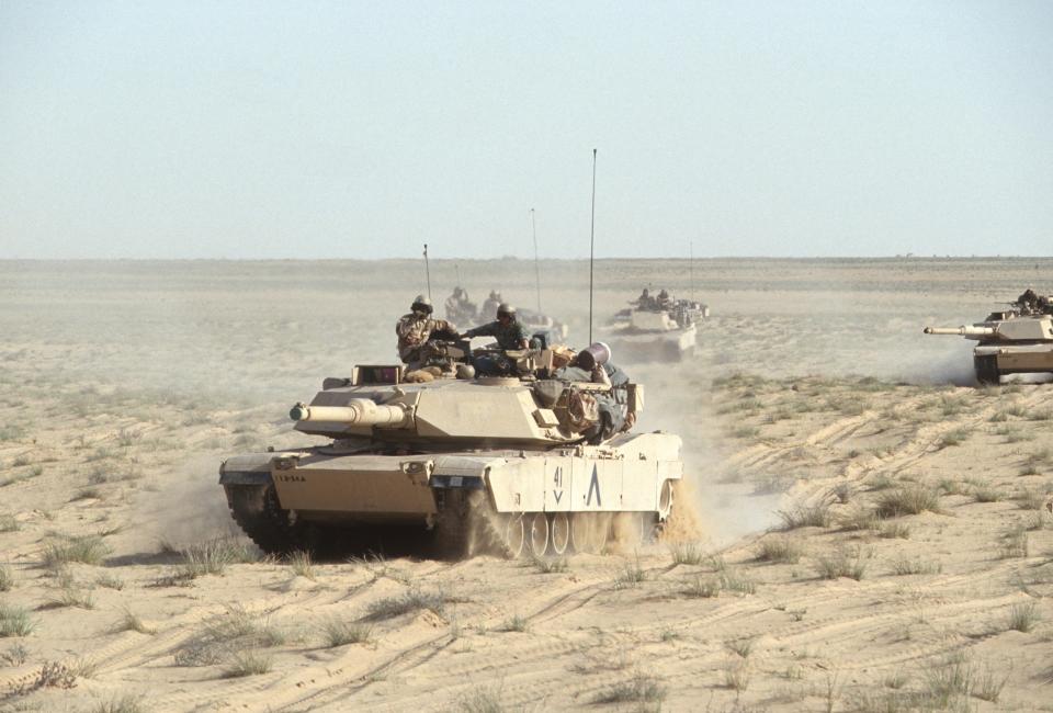 Tanks cross the desert.