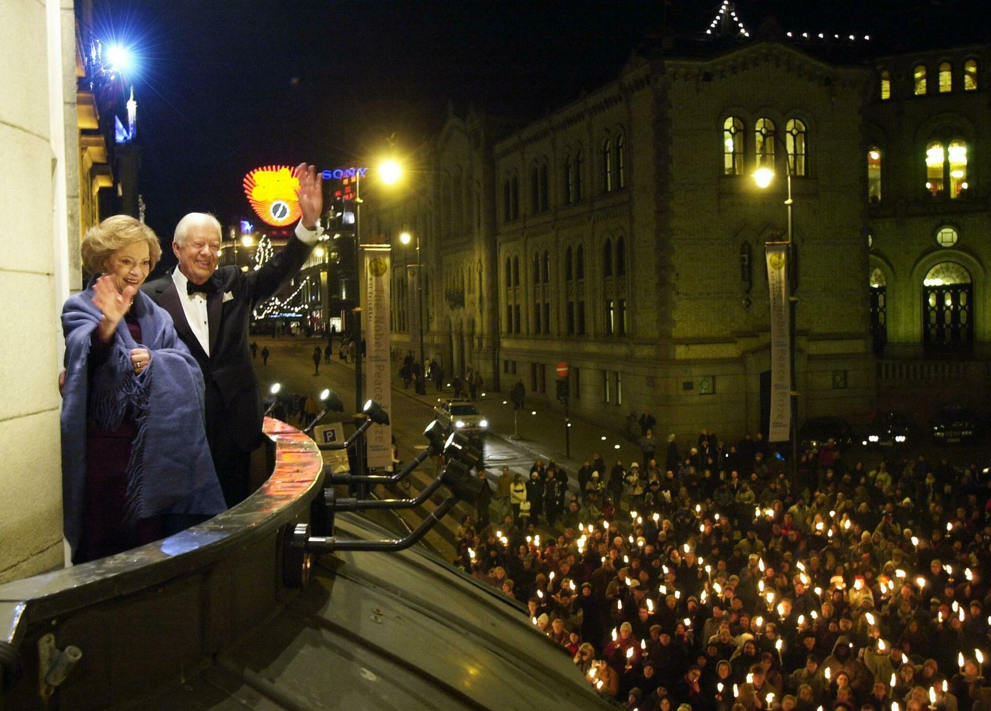 December 10, 2002: Nobel Peace Prize winner, former US President Jimmy Carter (2ndL) and his wife Rosalynn (L), greet wellwishers during a torchlight procession, from the balcony of Grand Hotel in downtown Oslo, prior the Norwegian Nobel Committee's banquet.