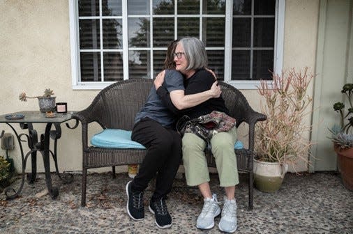 In June, Nikki Jursak, a former co-worker who hosted Joanne Erickson in her home during her final days, embraces Naomi Waka, Erickson&#x002019;s volunteer advocate. A month earlier, Jursak found Erickson dead in the room where she had been staying.