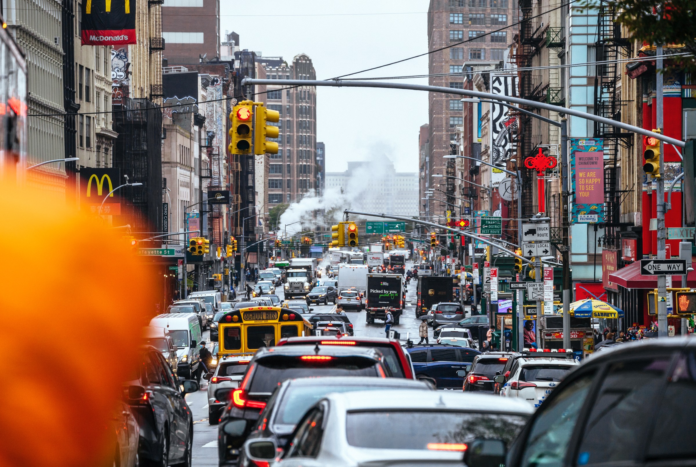 Cars, trucks, and buses crowded on a busy city street.