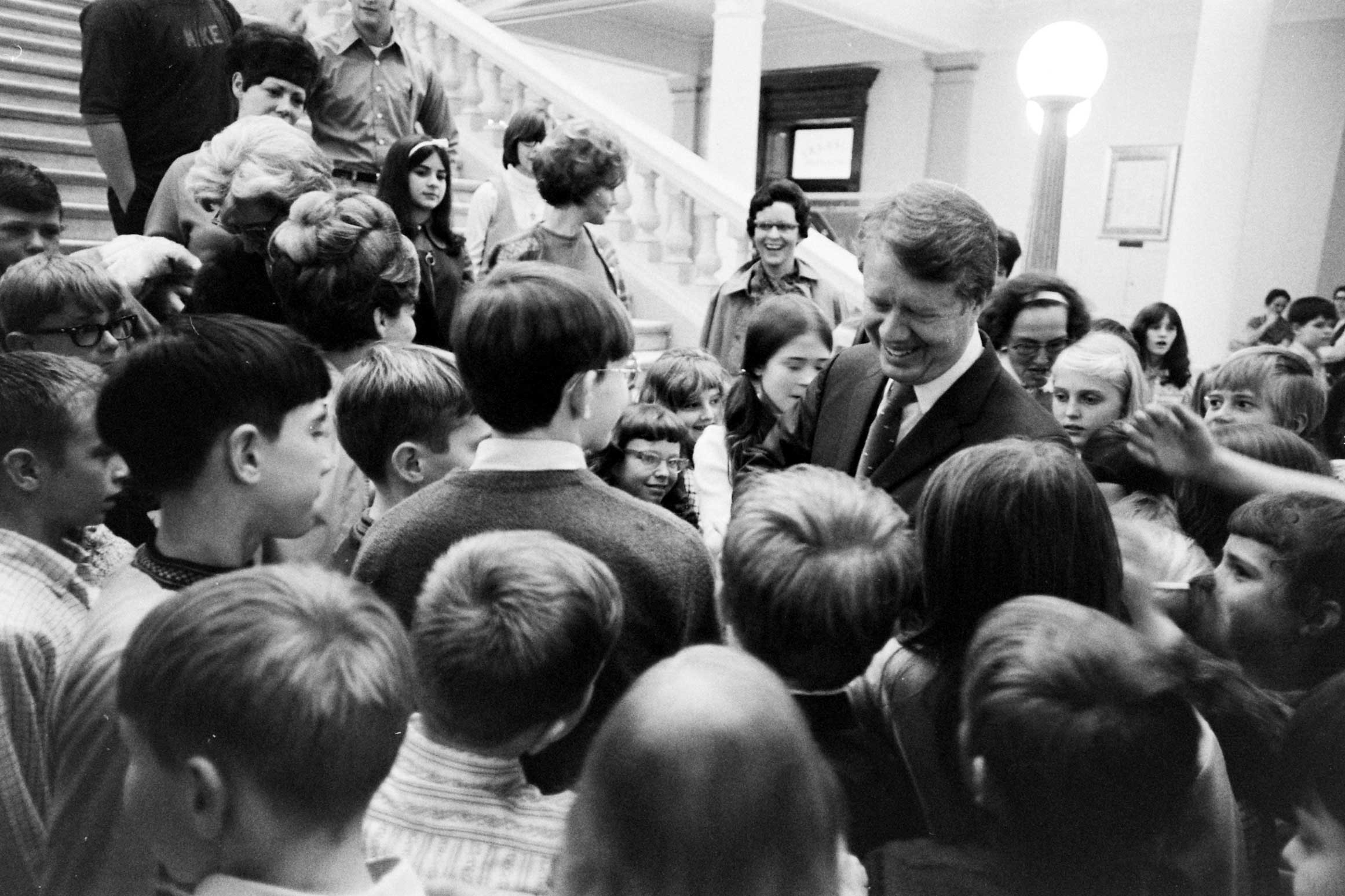 A photo showing Jimmy Carter crowded by children.