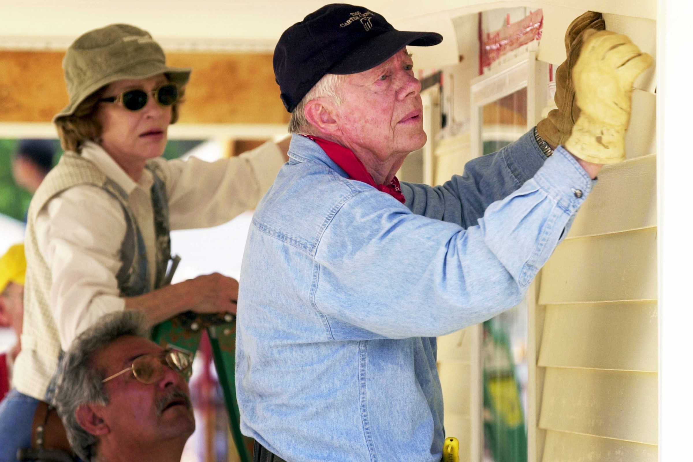 Jimmy Carter and his wife, Rosalynn Carter, attach siding to the front of a Habitat for Humanity home being built in LaGrange, Georgia, on June 10, 2003.