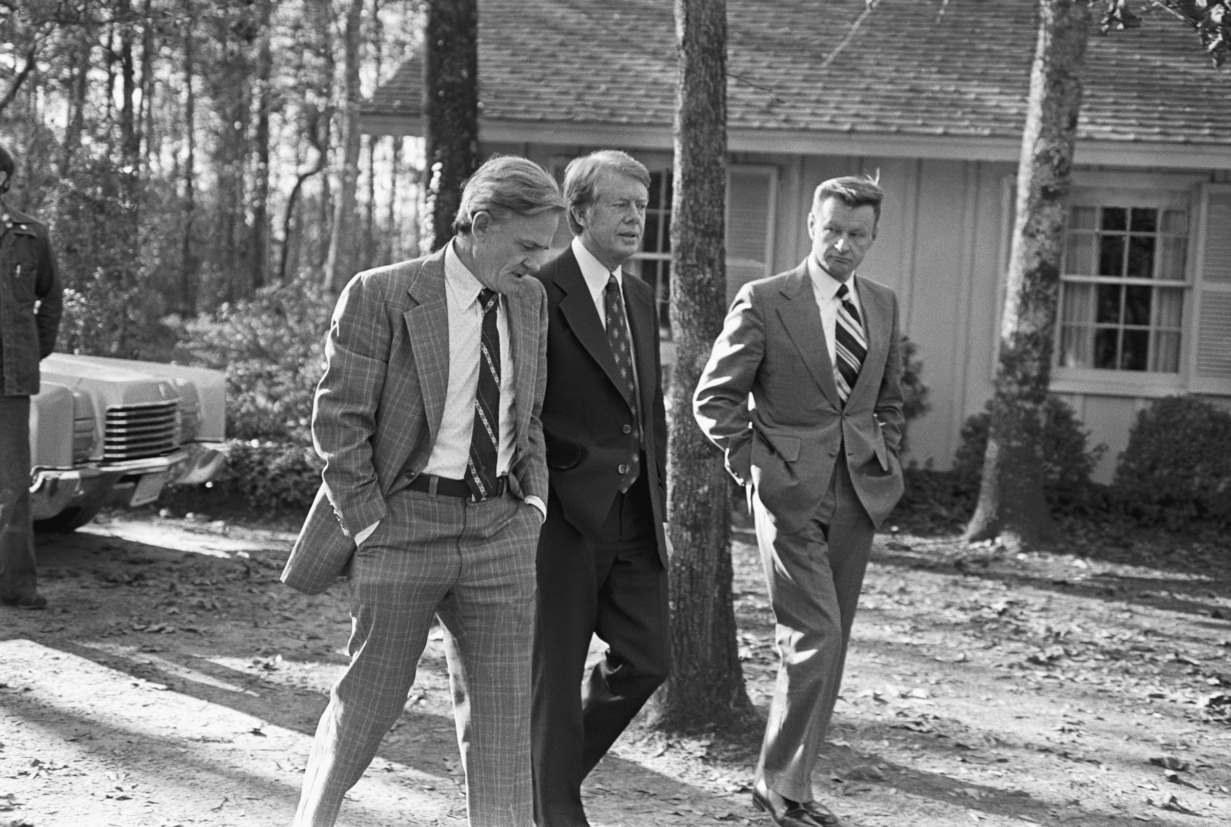 Carter appointees Charles Schultze and Zbigniew Brzezinski walk with Carter to his home on December 16, 1976.