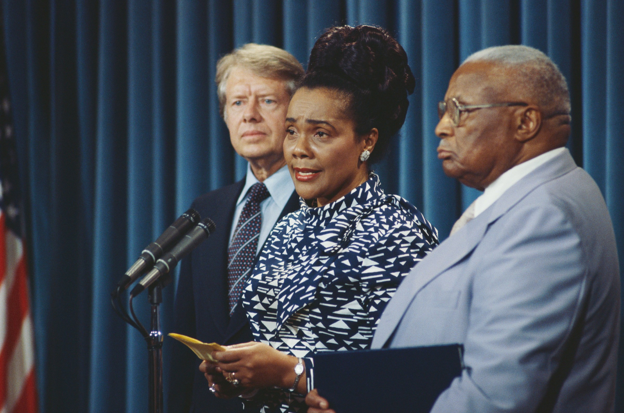 Coretta Scott King speaks while flanked by President Jimmy Carter and her father-in-law, Martin Luther King Sr., on July 11, 1977.