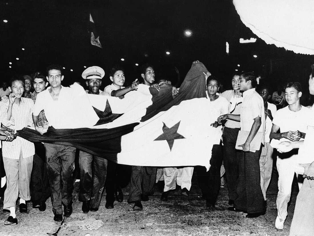 Panamanian students carry a large flag along Fourth of July Avenue in Panama City, Jan. 9, 1964, after Canal Zone police fired at them with tear-gas guns. Two days of anti-U.S. rioting that followed a fight over flag rights in the Canal Zone resulted in the deaths of over 20 Panamanians and four U.S. soldiers.