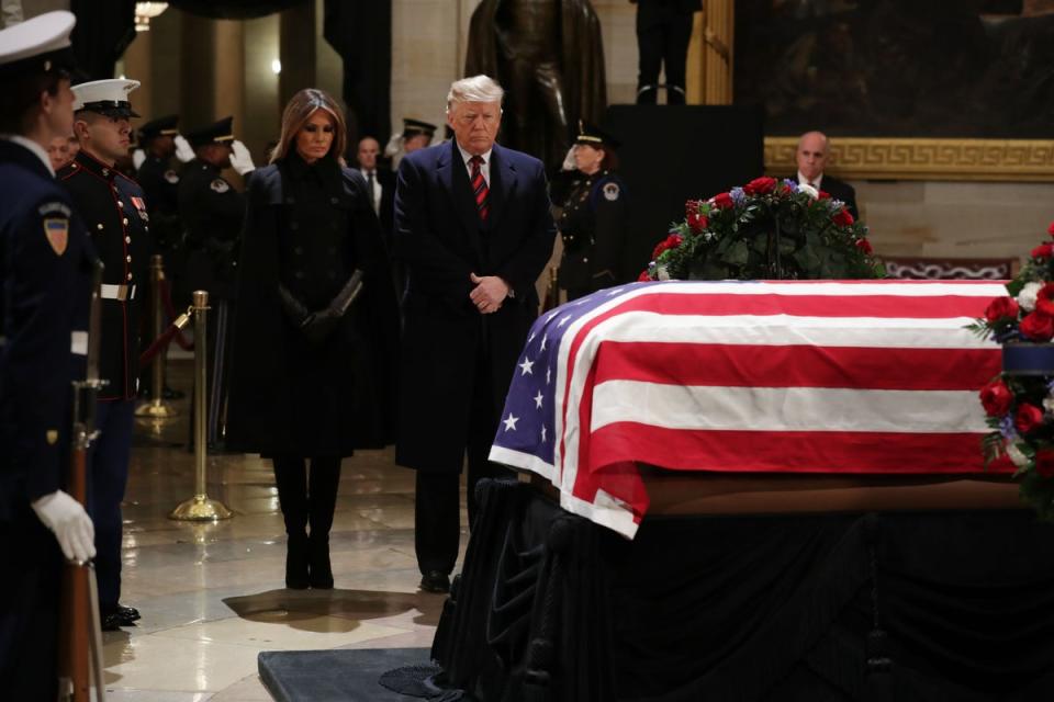 President Donald Trump and first lady Melania Trump pay their respects as former President George HW Bush lies in state in the Capitol Rotunda on 3 December, 2018 in Washington, DC (Getty Images)