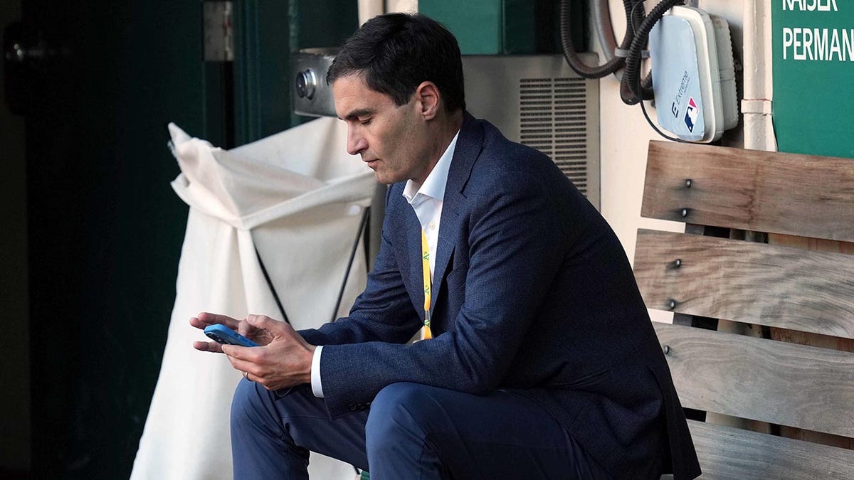 Dave Kaval sits in dugout