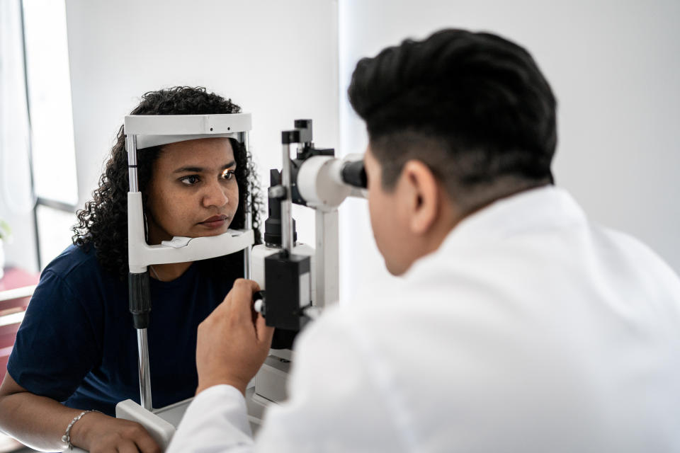 A person undergoing an eye exam with an optometrist using a slit lamp, focusing on eye health and assessment