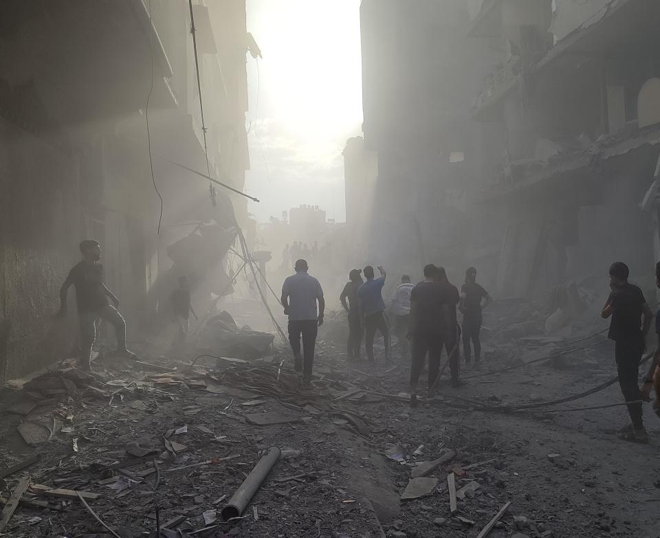 Palestinians walk among debris following the Israeli attack on the courtyard of Kamal Adwan Hospital and its surrounding buildings in Beit Lahia, northern Gaza, Dec. 25, 2024. / Credit: Khalil Ramzi Alkahlut/Anadolu/Getty