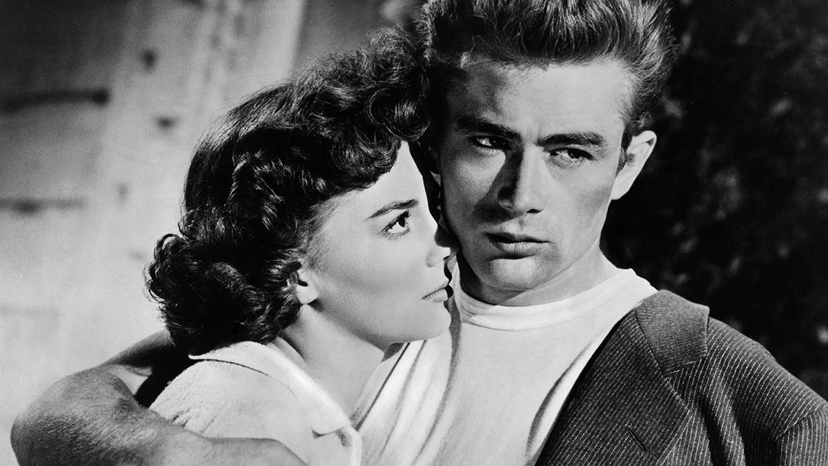 Natalie Wood leaning on James Dean as they both wear white.