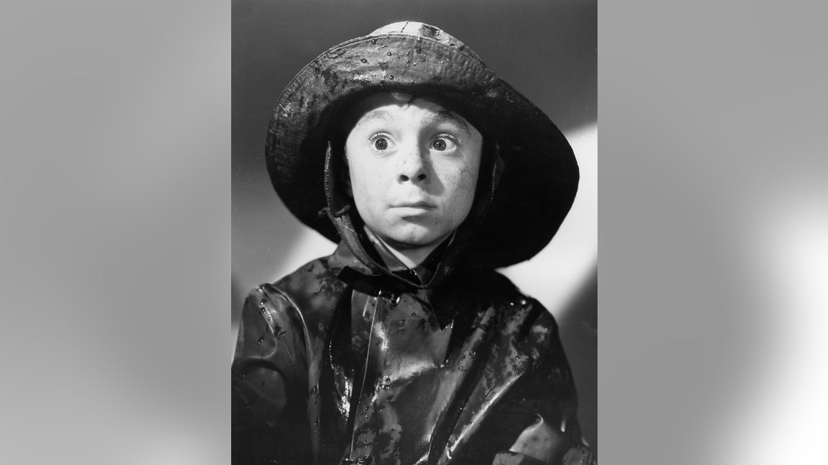 Carl Switzer in a rain jacket and hat as Alfalfa looking bewildered