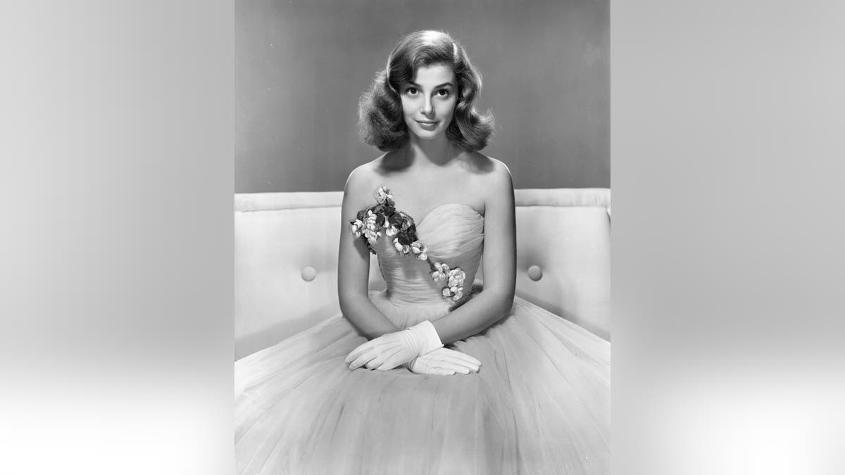 Pier Angeli posing in a strapless gown with flowers.