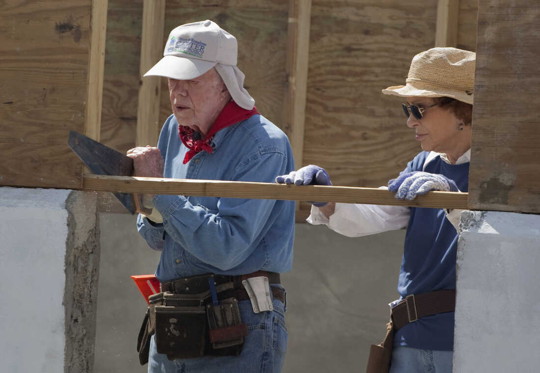November 7, 2011: Former U.S. President Jimmy Carter, left, cuts wood as he works on a home as his wife Rosalynn looks on as they visit a Habitat for Humanity project in Leogane, Haiti. The Carters joined volunteers from around the world to build 100 homes in partnership with earthquake-affected families in Haiti during a week-long Habitat for Humanity housing project. (AP Photo/Ramon Espinosa)