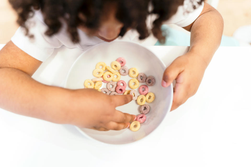 Close up top view of kid with afro hair eating breakfast in the morning. Healthy lifestyles.