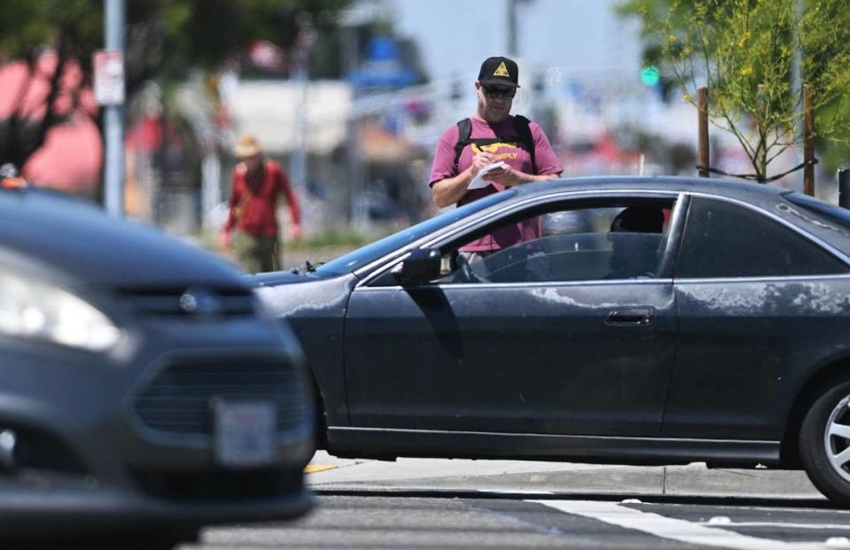 Fresno Bee columnist Marek Warszawski takes notes as he pauses at Shields Avenue on his hike south along Blackstone Avenue Wednesday, May 8, 2024 in Fresno.