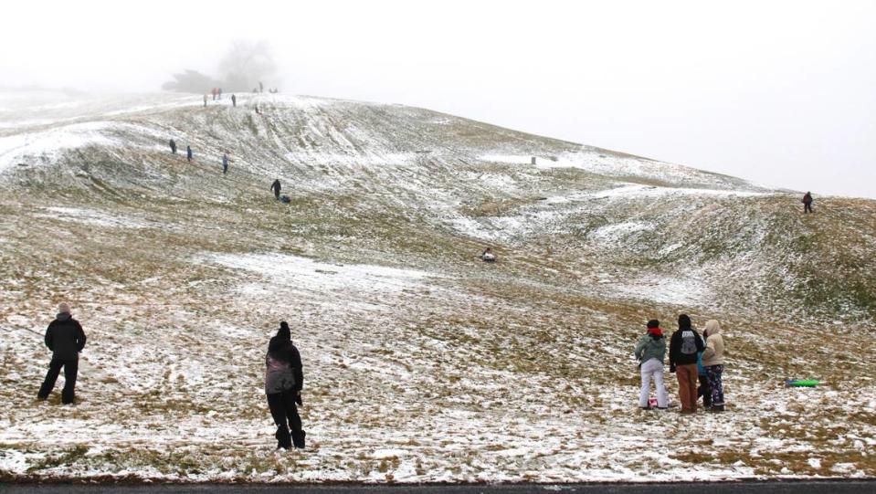 Families sled and play in the snow at the foggy Simplot Hill near the corner of Cartwright and Bogus Basin roads in Boise on New Year’s Day.