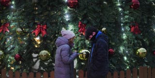 Pedestrians look at Christmas decorations in the centre of Russian controlled Mariupol