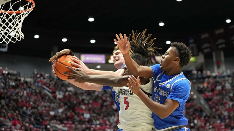 Pharaoh Compton (middle) was among the players grappling for the ball in an Aztec vs. Air Force game.