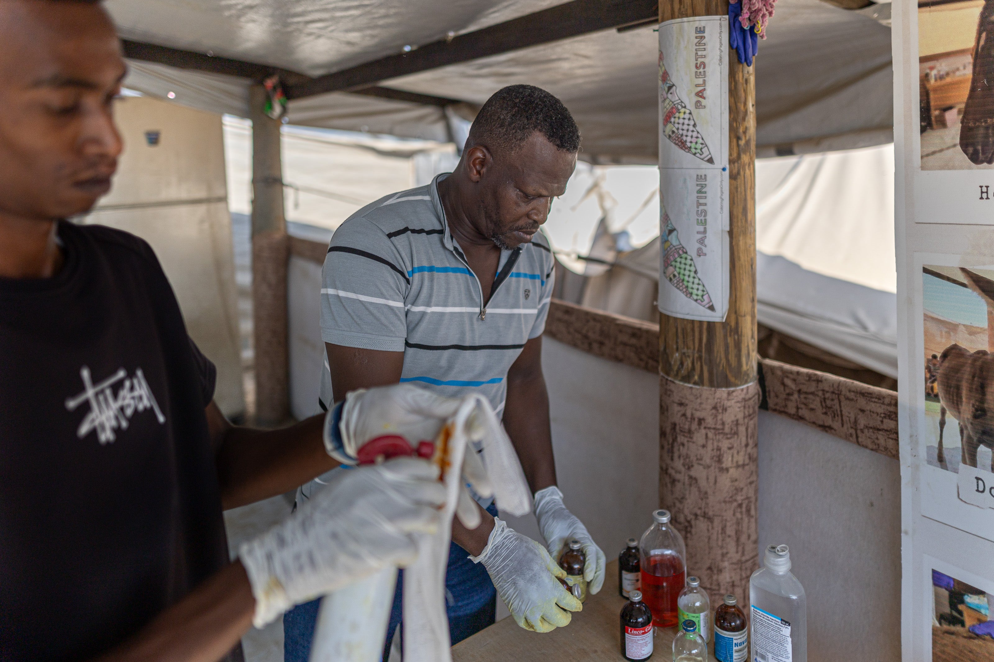 Saed Al-Err, the charity’s founder, and his son Aeed, prepare medicine at the Sulala Animal Rescue clinic in Deir al-Balah, Gaza, in October