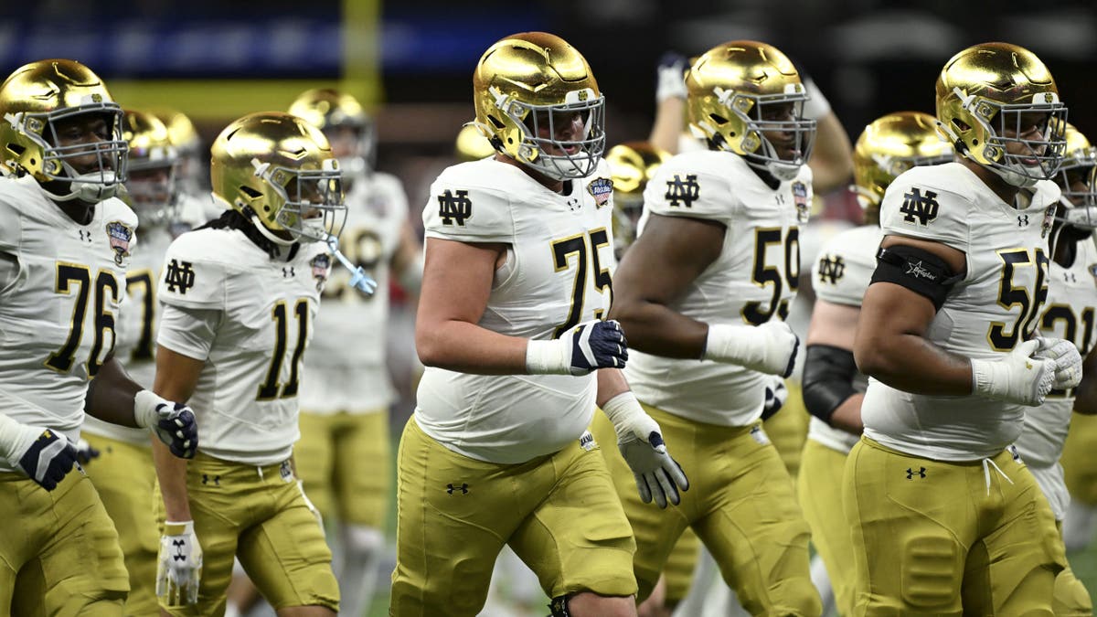 Notre Dame players run
