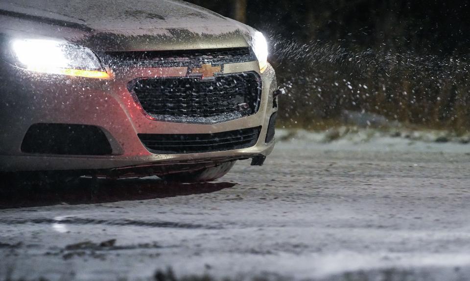 Cars drive through snow and on icy roads in the late hours on Thursday, Dec. 23, 2022 in Indianapolis. A winter storm with negative temperatures threatens holiday travel.