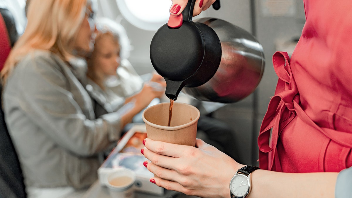 flight attendant pouring coffee