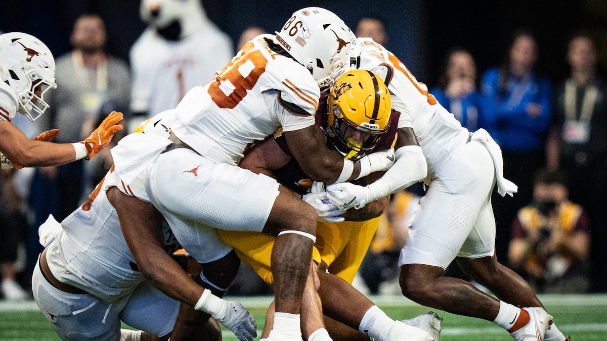 Texas defense, including Texas Longhorns defensive lineman Dorian Black (86) stop Arizona State Sun Devils running back Cam Skattebo (4) in the first quarter as the Texas Longhorns play the Arizona State Sun Devils in the Peach Bowl College Football Playoff quarterfinal at Mercedes-Benz Stadium in Atlanta, Georgia, Jan. 1, 2025.