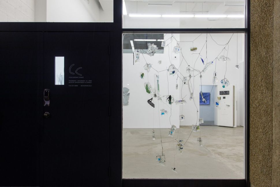 An installation of fragmented glass hanging from a window