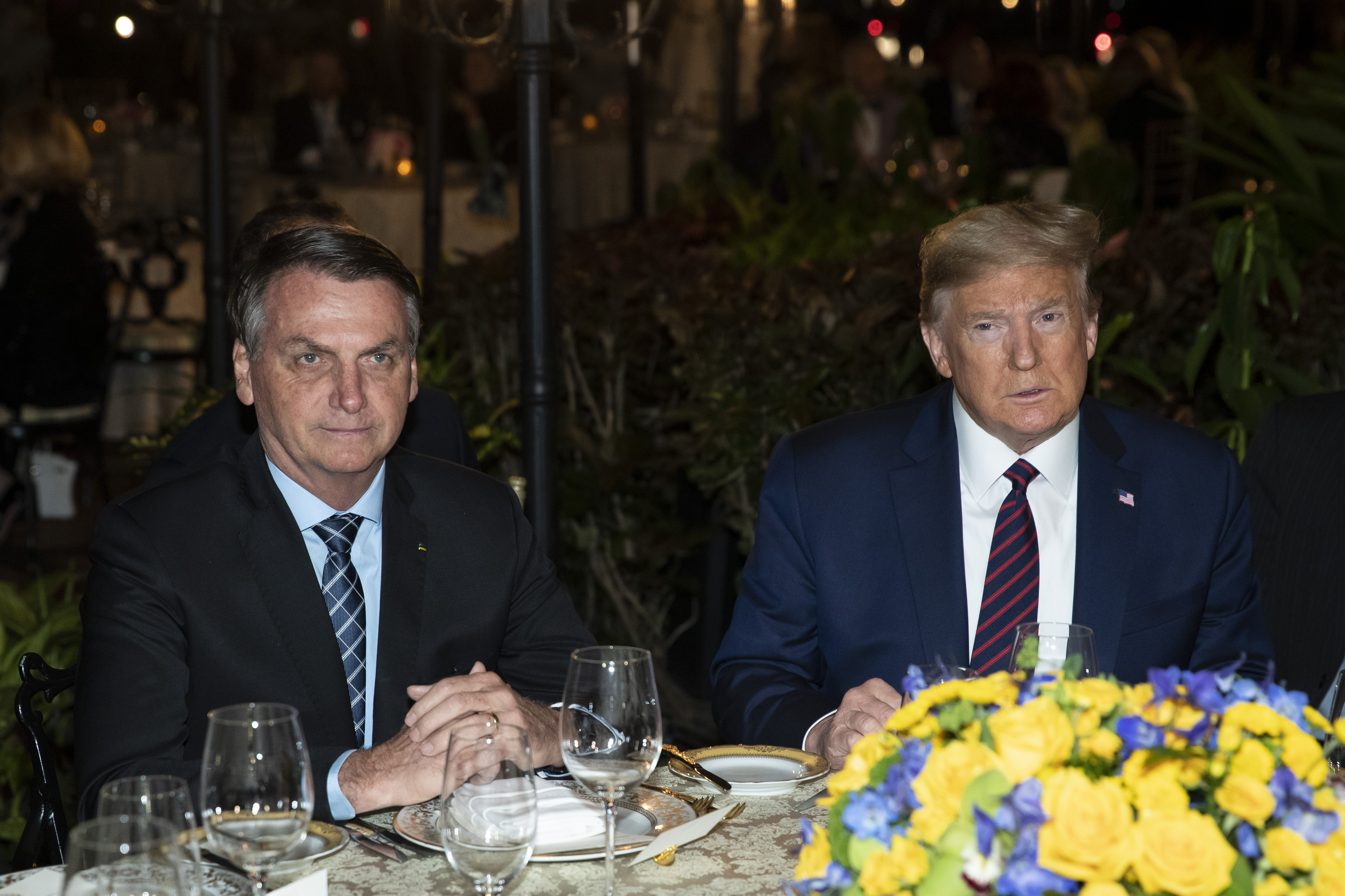 FILE - President Donald Trump, right, sits alongside Brazilian President Jair Bolsonaro during a dinner at Mar-a-Lago in Palm Beach, Fla., March 7, 2020. (AP Photo/Alex Brandon, File)