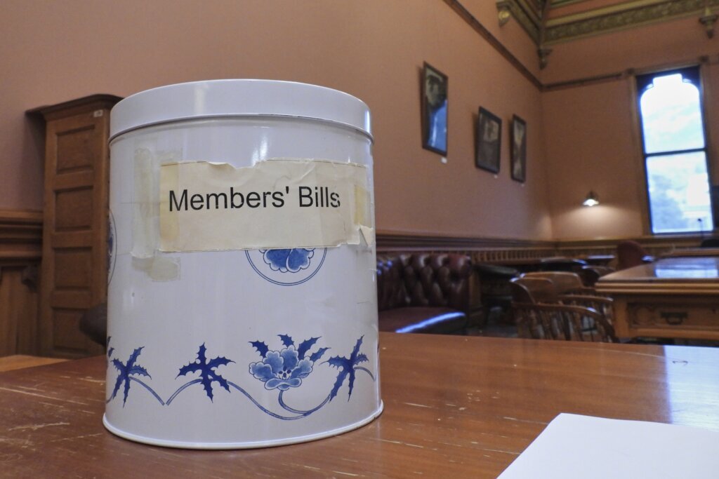 In New Zealand’s Parliament, a battered cookie tin decides which new laws get debated