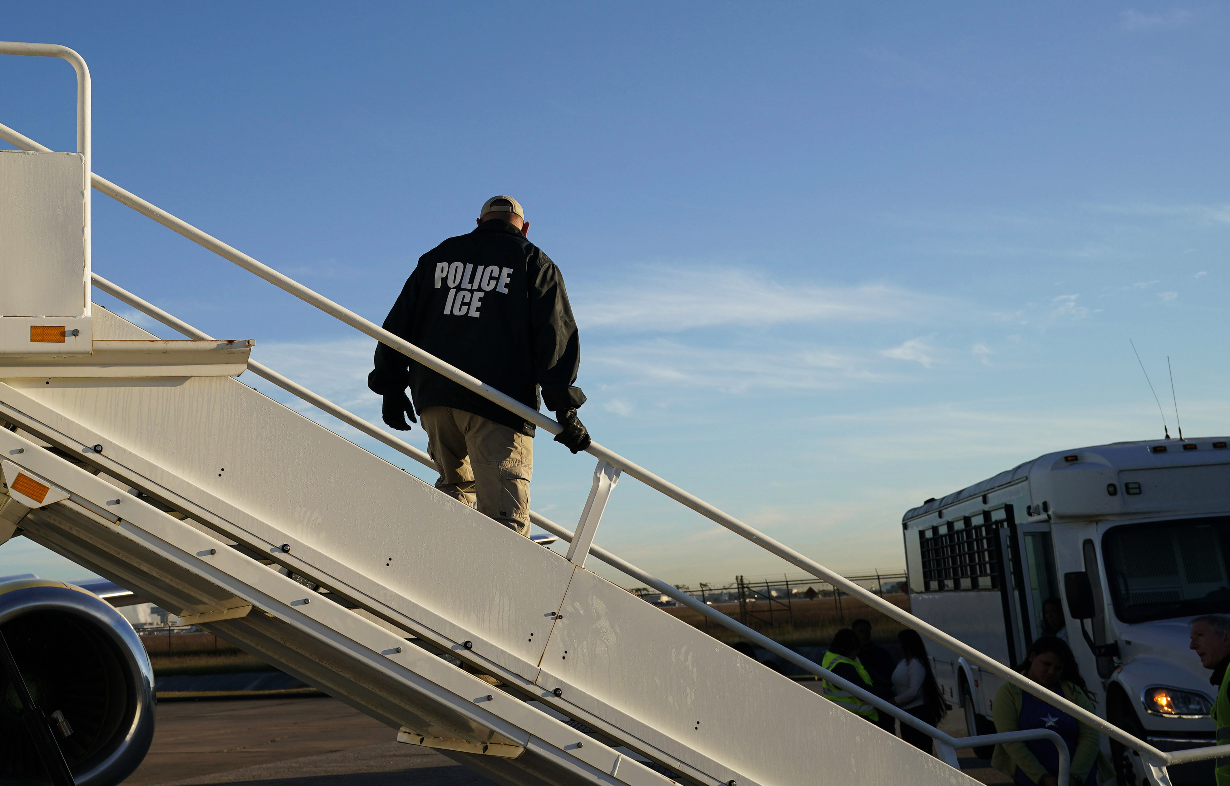 FILE - In this Nov. 16, 2018, file photo, an officer watches as immigrants who entered the United States illegally are deported on a flight to El Salvador by U.S. Immigration and Customs Enforcement in Houston. Civil rights activists complained Monday of the potential for widespread abuse following confirmation that states have scanned millions of driver's license photos on behalf of Immigration and Customs Enforcement officials without the drivers’ knowledge or consent. (AP Photo/David J. Phillip, File)
