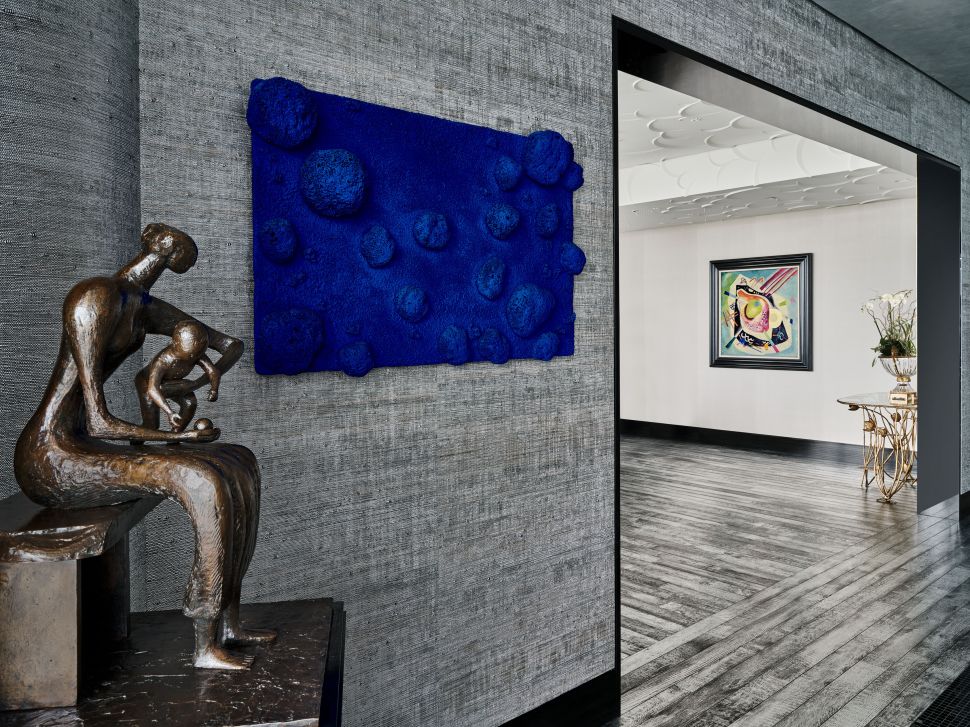 Image of a house with a blue sponge work of art, a bronze sculpture and a abstract painting.